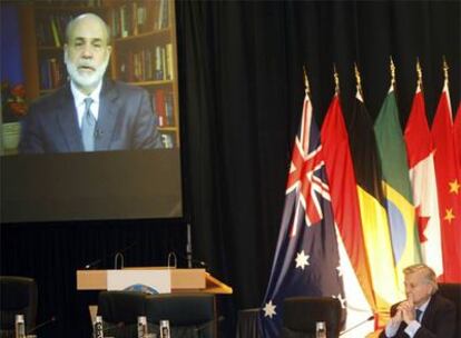 Trichet escucha la videoconferencia de Bernanke durante la International Monetary Conference en Barcelona.