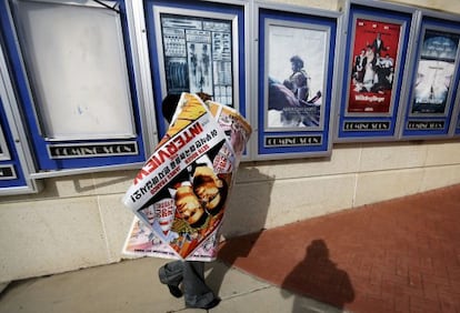 Funcionário retira cartazes de A Entrevista de um cinema em Atlanta.
