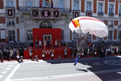 Un paracaidista aterriza ante las autoridades que presiden los actos en la Puerta de Sol en 2016.