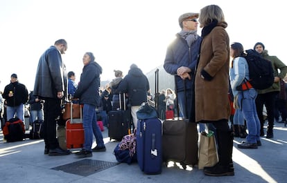 Viajeros esperan en los alrededores de la estación de Atocha tras ser desalojados por la policía.