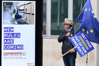 El activista Steve Bray sostiene una bandera de la UE frente una parada de autobús con un anuncio proBrexit en Westminster, en Londres, el miércoles.