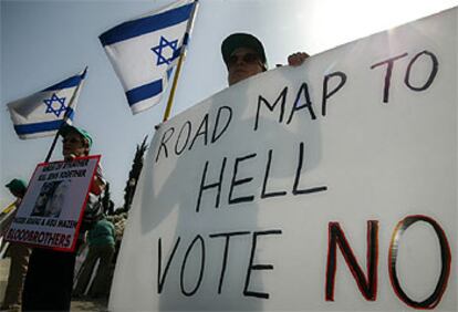 Un colono judío sostiene una pancarta que dice: "La Hoja de Ruta al infierno. Vota no".
