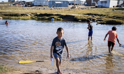 Un grupo de niños inuit juega en aguas del Ártico canadiense, el 15 de agosto de 2019, en la ciudad de Pond Inlet