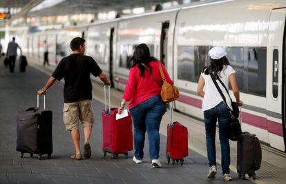 Tres viajeros bajan de un AVE en la estaci&oacute;n de Atocha de Madrid