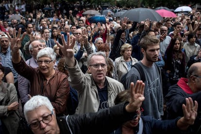 Uma multidão levanta os quatro dedos de uma mão, em referência à bandeira catalã, enquanto espera para votar em Barcelona.