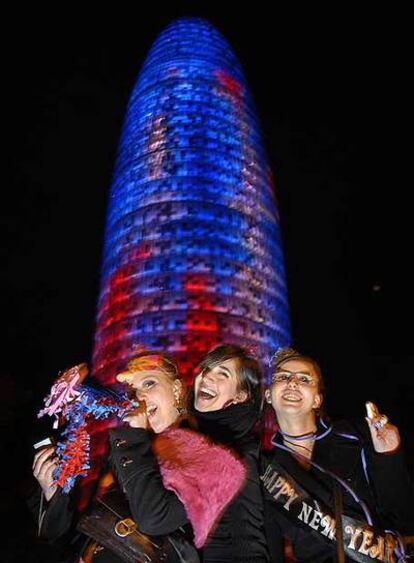 Tres jóvenes celebran la llegada del Año Nuevo al pie de la Torre Agbar, que tuvo poco éxito de concurrencia.