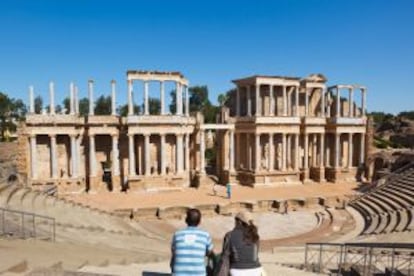 Dos turistas contemplando, desde las gradas, el teatro romano de Mérida (Badajoz).