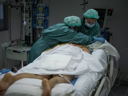  En la imagen, varias enfermeras preparan a una mujer recien ingresada para su estancia en la UCI.