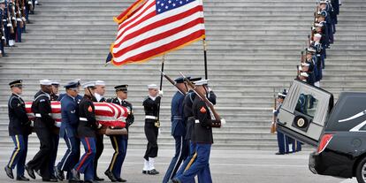 La guardia de honor militar lleva el ataúd del ex presidente George H.W. Bush hacia el coche fúnebre.
