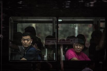 Dos pasajeros observan la calle a través de los ventanales de un autobús, en la plaza de Tiananmen (China) En medio de fuertes medidas de seguridad, Pekín se prepara con varias semanas de antelación para la jornada que celebra el 70 aniversario de la fundación de la República Popular China.