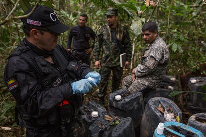 Un agente de la policia judicial toma una muestra de un químico líquido utilizado en la extracción de clorhidrato de cocaína durante un operación para la destrucción de un laboratorio de cristilización escondido en las selvas del Guaviare, en la Amazonia colombiana, en mayo de 2019.