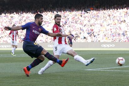 Luis Suárez (izquierda) lanza el esférico ante la presión de Yeray Álvarez.