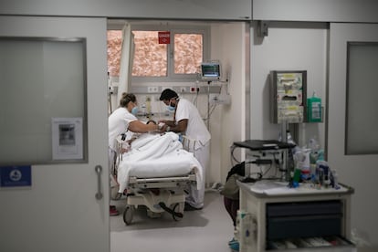 Enfermeros atienden en un paciente en el Hospital Vall d'Hebron.