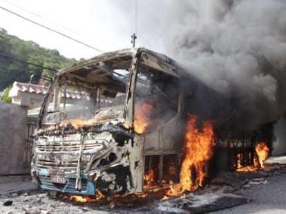 Un autob&uacute;s incendiado en la favela de Caramujo.
