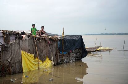 Residentes indios afectados por las inundaciones se preparan para trasladar sus pertenencias a un terreno más seco lejos de la orilla del río Ganges en Sangam (India).