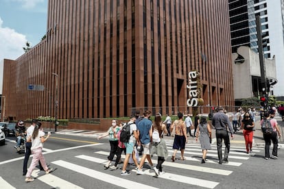 Transeuntes caminham em frente ao Banco Safra na Avenida Paulista, em São Paulo (Brasil). 