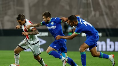 Óscar Trejo, del Rayo Vallecano, intenta escapar de dos jugadores del Getafe el viernes en el estadio de Vallecas.