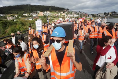 Dos hombres portan una simulación de un féretro en una manifestación, este domingo, por el futuro de las fábricas de Alcoa y Vestas, en A Mariña (Lugo).