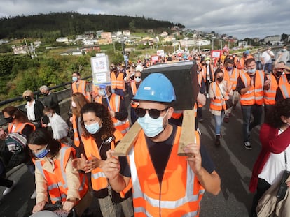 Dos hombres portan una simulación de un féretro en una manifestación, este domingo, por el futuro de  las fábricas de Alcoa y Vestas, en A Mariña (Lugo).