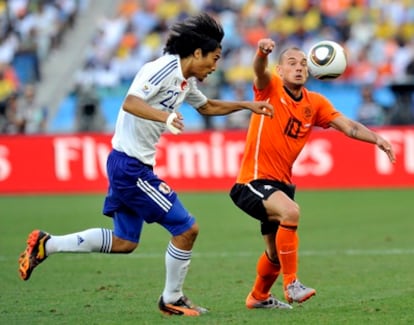Sneijder y el japonés Nakazawa luchan por un balón durante el último Mundial.