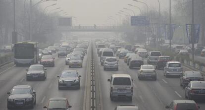 Vista de una carretera cubierta por una nube de polución en Pekín (China).