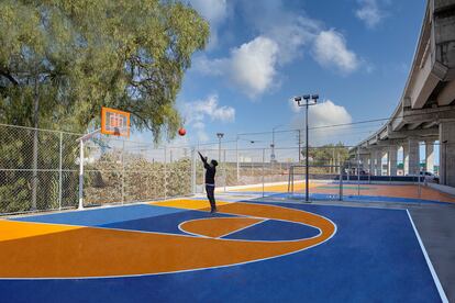 Un joven juega a baloncesto en una de las canchas del parque.