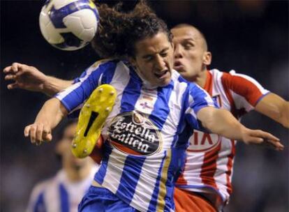 Guardado y Heitinga pelean por un balón.