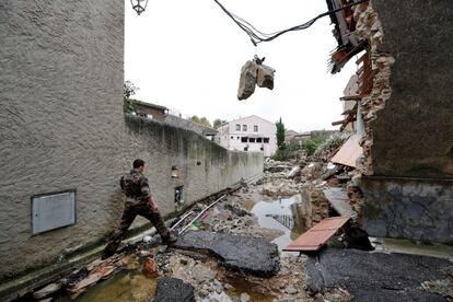 Un soldado camina entre los desperfectos provocados tras las inundaciones en Villegailhenc (Francia).