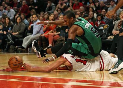 Rajon Rondo se tira encima de Joakim Noah para tratar de hacerse coon el balón.