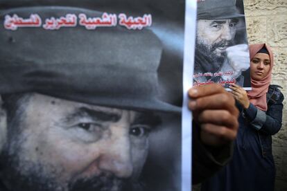 TOPSHOT - A Palestinian woman holds a posters of late Cuban leader Fidel Castro as people gather in Gaza city on November 28, 2016 to pay tribute him after his death.
Cuban revolutionary icon Fidel Castro died late November 25 in Havana, his brother, President Raul Castro, announced on national television. Castro's ashes will be buried in the historic southeastern city of Santiago on December 4 after a four-day procession through the country. / AFP PHOTO / MOHAMMED ABED