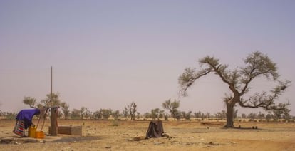 una mujer recoge agua de un pozo en Liboré, cerca de Niamey, una zona donde se registraron un gran número de retornados nigerinos de Libia.