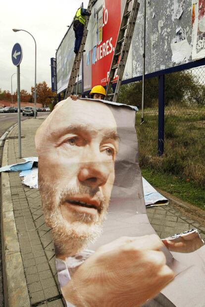 Dos operarios retiran los carteles electorales en Madrid.