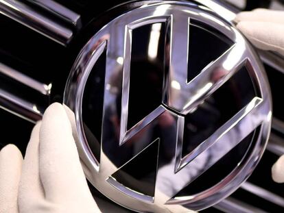 Un operario sostiene el logo de Volkswagen en una planta de la compañía en Wolfsburgo, Alemania.