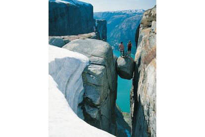 Dos ciclistas se asoman al Lysefjord, en Stavanger (Noruega), desde la roca colgante de Kjerag, situada a mil metros de altura sobre el fiordo.