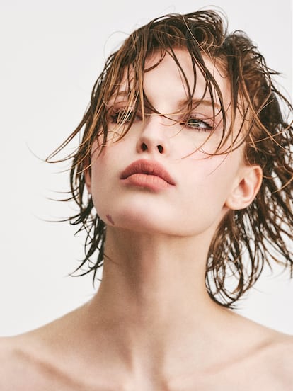 El pómulo se marca sutilmente con Prisme Libre Blush (tono Mousseline Lilas, 01) y la mirada se intensifica con la máscara de pestañas L’Interdit Couture Volume. El labio, mate, con el labial líquido Le Rouge Interdit Cream Velvet (Beige Doré, 12). Todo de GIVENCHY BEAUTY.