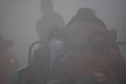 Habitantes de Harbin (China) se mueven por la ciudad en un triciclo, 21 de octubre de 2013. Por su parte, las autoridades educativas han cancelado las clases en todas las escuelas de primaria y secundaria de Harbin.