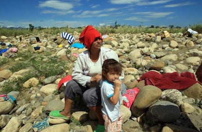 Una mujer y su hija lavan ropa en el río Táchira.