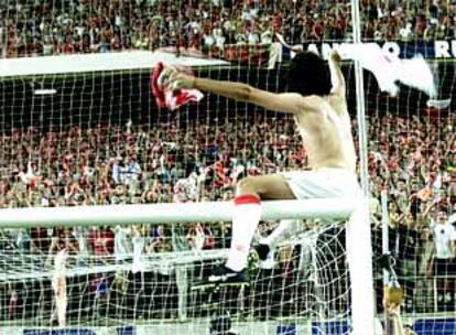 Gallardo celebra el ascenso subido al larguero de una portería.