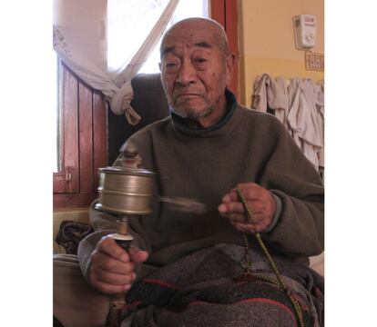 Tatop, de 93 años, menea su mane y thenga. Sobrevivió en las montañas de Mustang, donde conoció a su actual mujer. Tiene que sortear obstáculos para renovar su tarjeta de refugiado en Nepal.