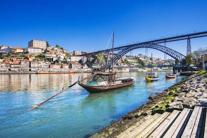 Para muchos, la vista más bonita de Oporto se obtiene justo desde enfrente, en Vila Nova de Gaia. El puente de Luis I, construido por un discípulo de Eiffel, une las dos ciudades. Se podría decir que Gaia es bella gracias a Oporto y viceversa. Desde su ribera, los viejos, grises y austeros almacenes de vino forman una especie de Alpes de pizarra, donde sobresalen anuncios de bodegas legendarias. Por razones de transporte, pero también climáticas, en Gaia se almacenaban —y aún siguen— las cubas de vino. Por dentro es un laberinto de intrincadas callejuelas. Algunos de los almacenes son ahora lugares de catas, asadores y hostales como The House of Sandeman, con inmejorables vistas a la otra fachada del río, la de Oporto.