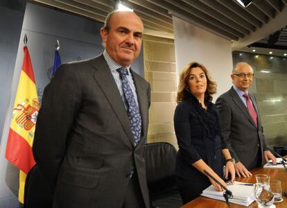 El ministro de Economía, Luis de Guindos, junto con Soraya Sáenz de Santamaría, y el titular de Hacienda, Cristóbal Montoro.