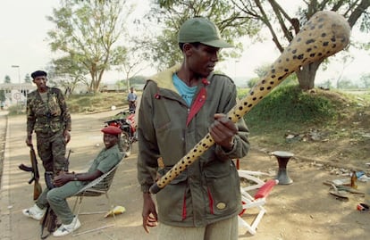 Un rebelde del Frente Patriótico de Ruanda contempla un bate con clavos cerca de un puesto de control de la milicia, el 7 de julio de 1994.