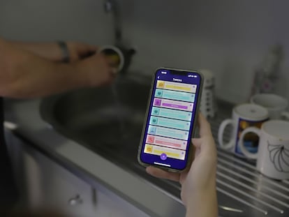 Una mujer usa la 'app' MeToca para gestionar el reparto de tareas del hogar.