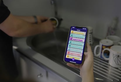 Una mujer usa la 'app' MeToca para gestionar el reparto de tareas del hogar.
