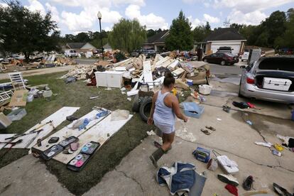 Una mujer camina entre los destrozos, frente a su casa, en Denham Springs, Luisiana (EE.UU).