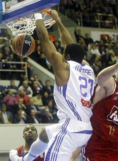 El pívot estadounidense del Real Madrid Jeremiah Masseym encesta ante los jugadores del CAI