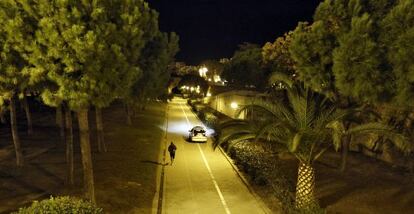 Un coche de policía y un deportista en el jardín del Turia.