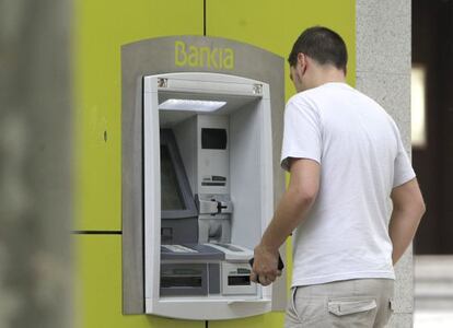 Un hombre saca dinero de un cajero automático.
