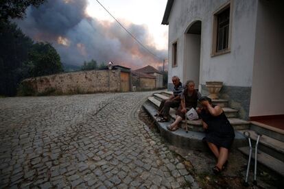 Vecinos del pueblo de Fato esperan la llegada del incendio.