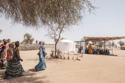 Son llaves que abren cerrojos al agua en el Sahel. Las llaves que abastecen a su familia y a su comunidad de hidratación en un invasivo calor que supera los 50 grados, de productos frescos cultivados por ellas, de pasto para su ganado, de higiene, de salud, de comercio. Son las llaves de un gran candado que aguarda el poder de facilitar la vida en las aldeas semiáridas de Douly y Ndiama, en Senegal. Un país que registra 1,7 millones de personas subalimentadas, (cuyo consumo habitual de alimentos es insuficiente para proporcionarle la cantidad de energía alimentaria necesaria para llevar una vida normal, activa y sana) y que sufre sequías y lluvias erráticas, deforestación o degradación de la tierra, un patrón que se repite en esta región africana. Y son ellas, las mujeres, las que atesoran la apertura de esa trampilla que permite a su pueblo disfrutar del bien cristalino que se acumula durante la estación de lluvia en unas cisternas de 15 metros cúbicos situadas al lado de sus cabañas. En la imagen, un grupo de mujeres se acerca a una cisterna en Ndiama Peulh, en la región de Louga, en Senegal.